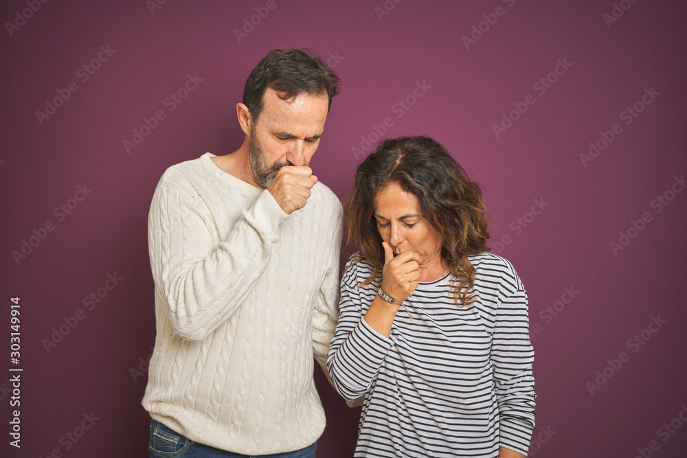 Naklejka premium Beautiful middle age couple wearing winter sweater over isolated purple background feeling unwell and coughing as symptom for cold or bronchitis. Healthcare concept.