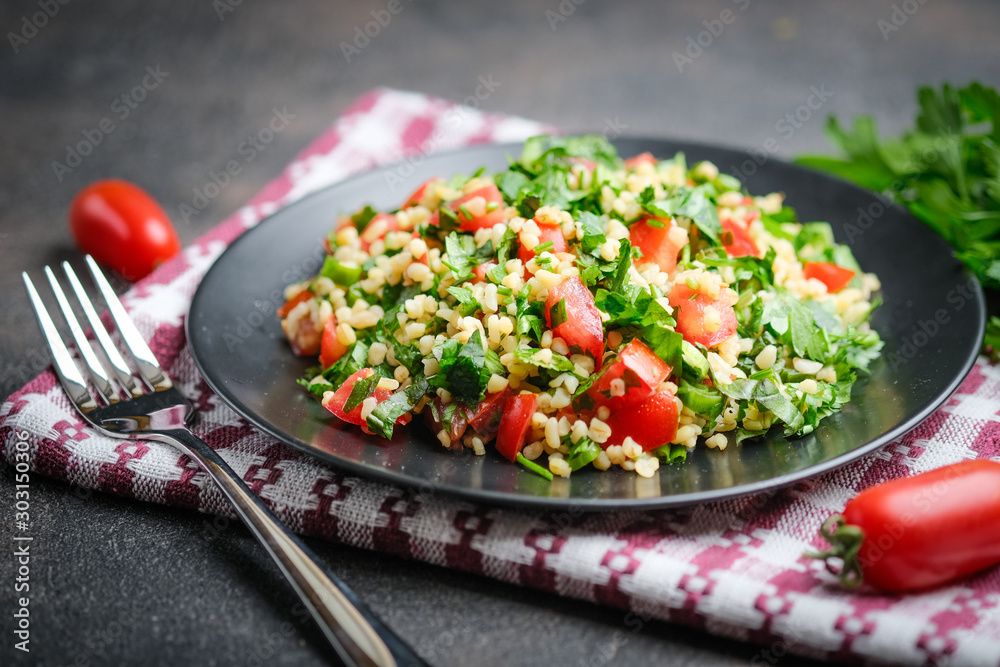 Traditional oriental salad Tabbouleh with bulgur and parsley on a dark background Traditional oriental salad Tabbouleh with bulgur and parsley on a dark background