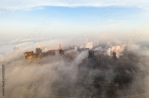 Aerial view. Pipes Throwing Smoke in the Sky. Large Plant on the Background of the City. © Dmytro Kosmenko