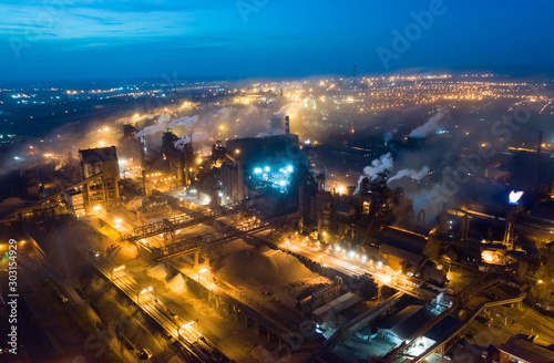 Aerial view. Emission to atmosphere from industrial pipes. Smokestack pipes shooted with drone. Night scene