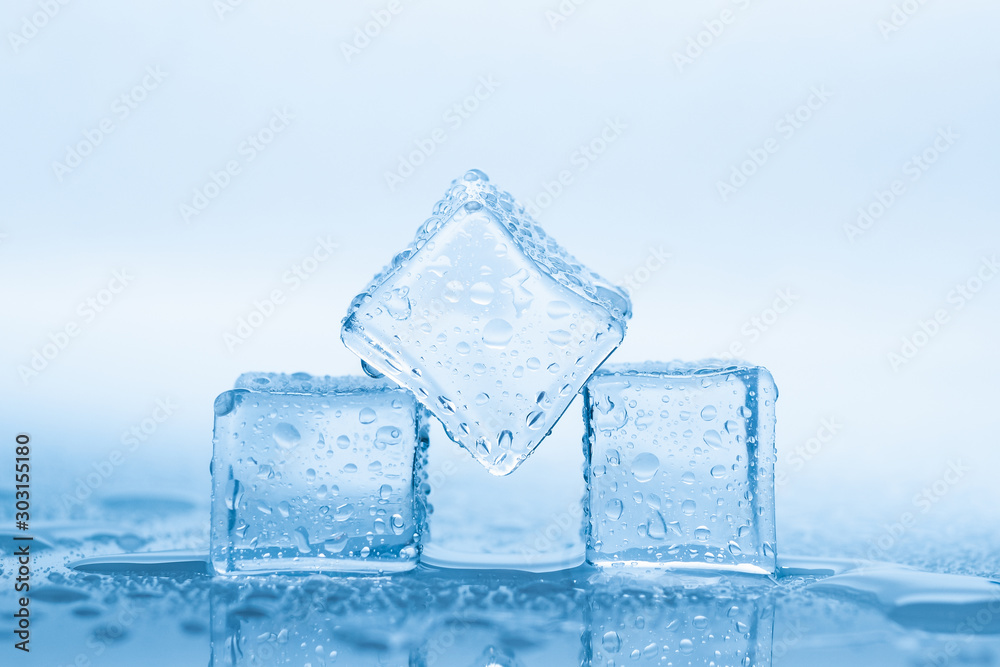 Ice three cubes with drops water clean on blue background Ice three cubes with drops water clean on blue background