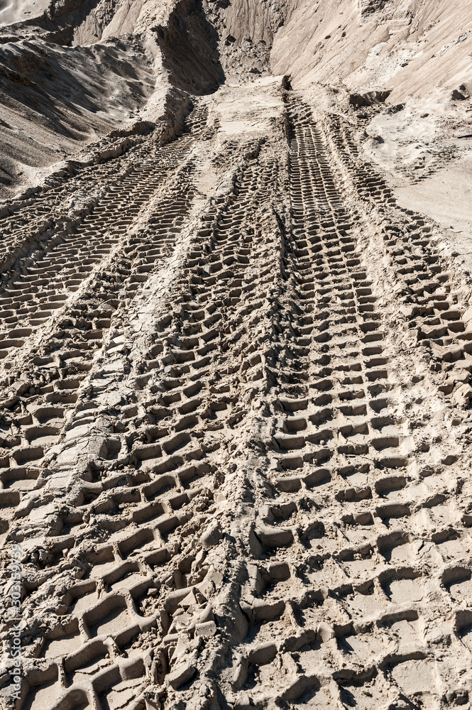 Naklejka premium Earth mover tire tracks in sand quarry