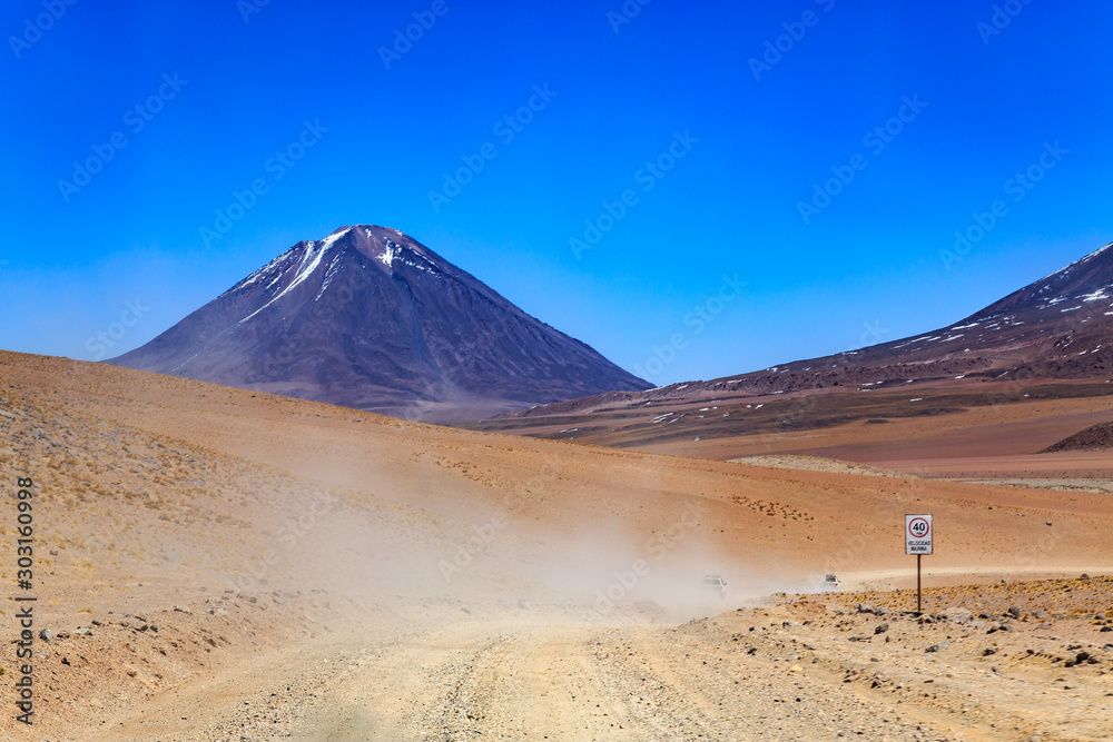 Dirt road ina landscape of the majestic Andes mountain range in Bolivia, South America