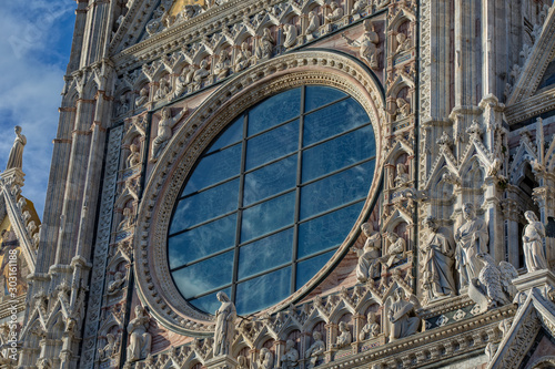 Siena Cathedral is a famous Italian romanesque-gothic cathedral with a striking facade is crowded with sculptures and architectural details, Tuscany, Italy