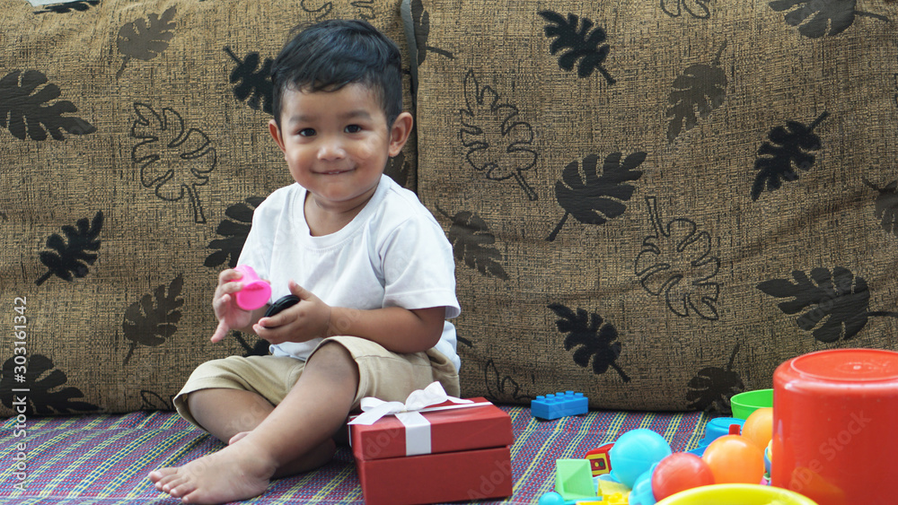 Naklejka premium Cute happy & curious little Asian 1.6 year / 18 months old toddler baby boy child sitting in the beautiful cafe relax time on holiday Kid experience & discovery concept.