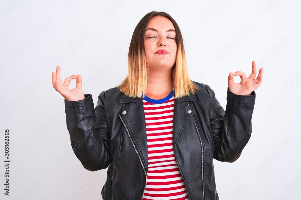 Young beautiful woman wearing striped shirt and jacket over isolated white background relax and smiling with eyes closed doing meditation gesture with fingers. Yoga concept. Young beautiful woman wearing striped shirt and jacket over isolated white background relax and smiling with eyes closed doing meditation gesture with fingers. Yoga concept.