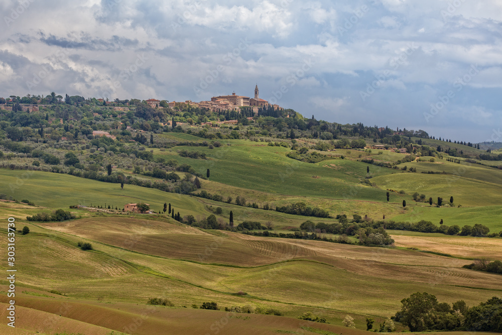 The rolling hills and green fields in Tuscany. Tuscany landscape in spring near the hilltop village Pienza, Tuscany, Italy