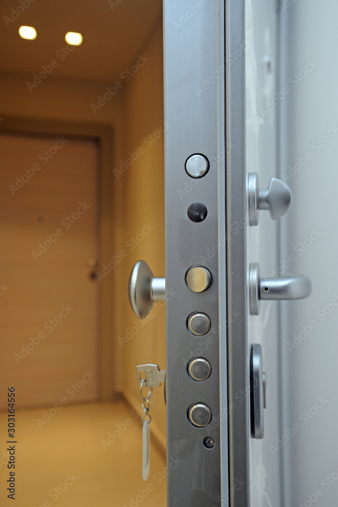 Obraz premium Porta blindata di sicurezza contro i furti negli appartamenti - chiavi di casa e acquisto di un nuovo immobile