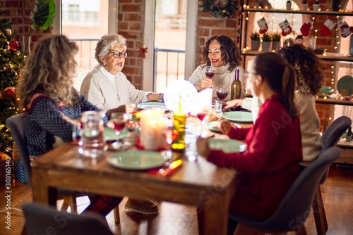 Beautiful group of women smiling happy and confident. Eating roasted turkey celebrating christmas at home