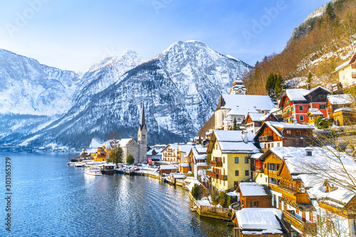 Obraz na płótnie Classic postcard view of famous Hallstatt lakeside town in the Alps with traditional passenger ship on a beautiful cold sunny day with blue sky and clouds in winter, Salzkammergut region, Austria w salonie