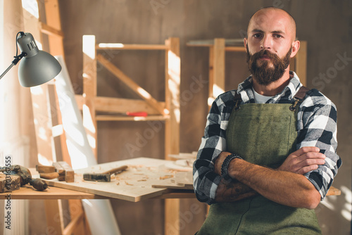 Portrait of a young male carpenter who works in his workshop.