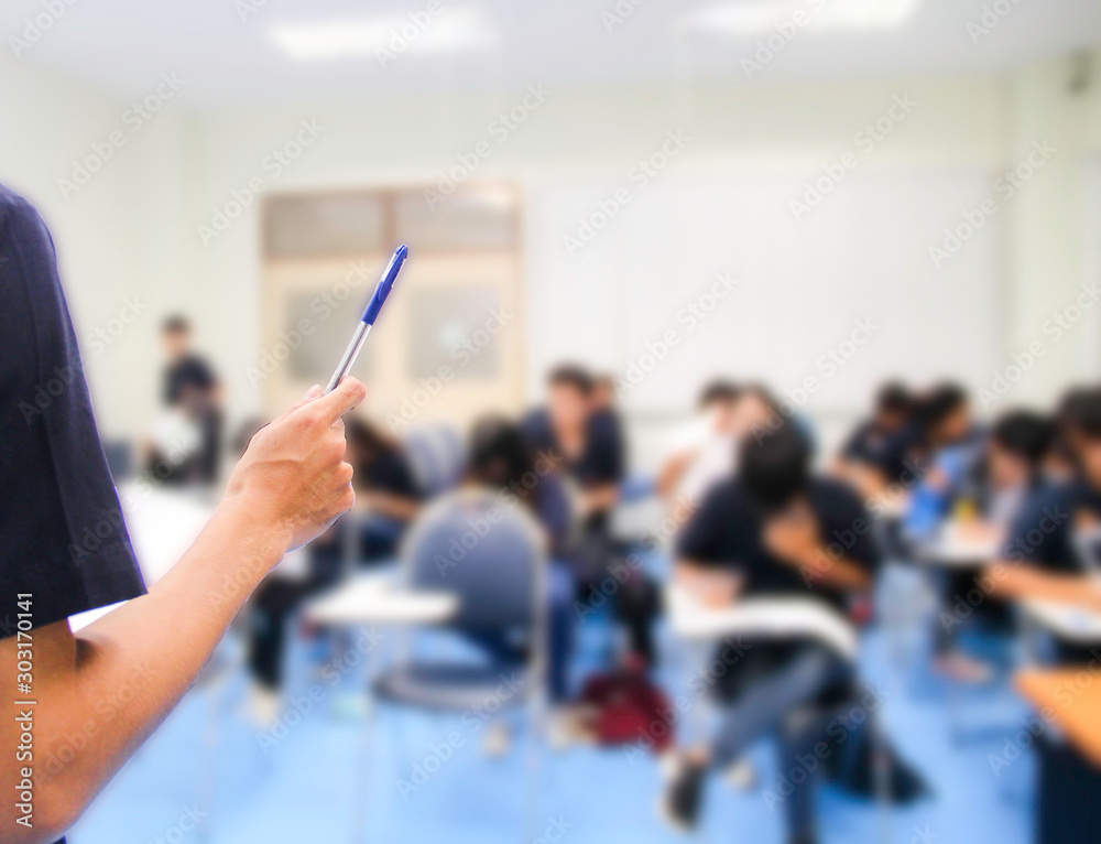 Teacher teach students and background of students during study or quiz,  test and exams in large lecture room / University classroom. Students are  in uniform classroom educational school. Stock Photo | Adobe Stock