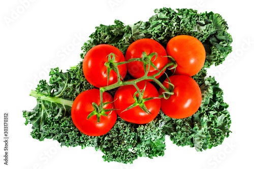 Tomatoes on a fresh leaf of kale cabbage isolated on white background. Top view.