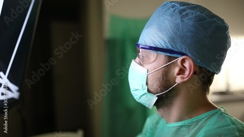 surgeon examines fluorography images on a monitor in an operating room of a medical office. photo