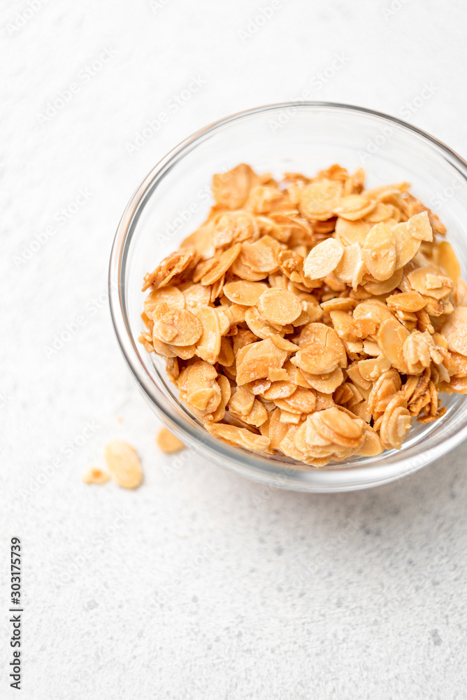 roasted walnut almond flakes on a light background roasted walnut almond flakes on a light background