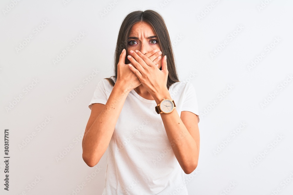 Young beautiful woman wearing casual t-shirt standing over isolated white background shocked covering mouth with hands for mistake. Secret concept. Young beautiful woman wearing casual t-shirt standing over isolated white background shocked covering mouth with hands for mistake. Secret concept.