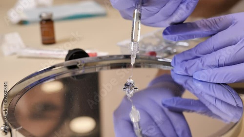 Experiment with hyaluronic acid filler for injections squeezed out from the syringe on the mirror surface showing it's strucrure photo