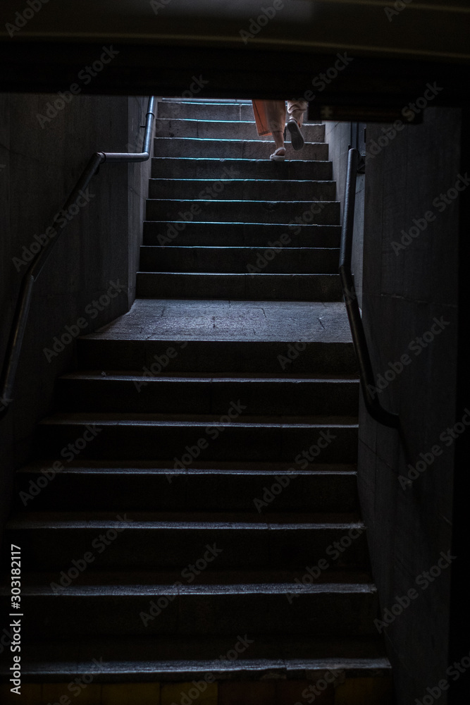  person on his back climbing subway stairs