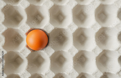 Concept outstanding healthy food, Notable one alone fresh brown chicken egg left in paper tray pit pattern background-flat lay