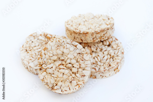 Round crunchy crispbreads on a white background. Round shaped cereal bread, healthy food without yeast. puffed multigrain crispbreads for diet.