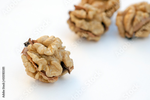 Peeled walnut closeup. Golden walnut kernel on a white background. Healthy foods.