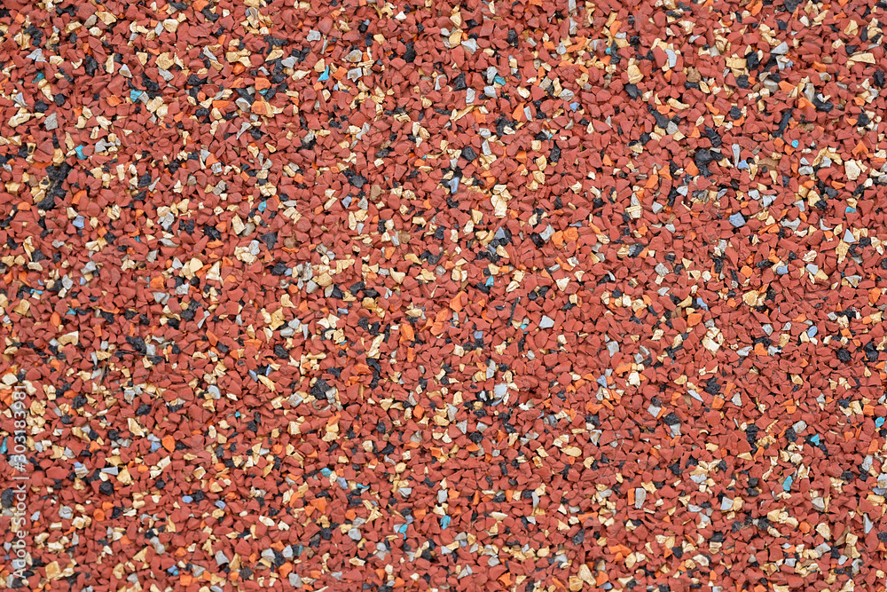 Covering the playground with rubber granules. Special red rubber coating for the playground. Multi-colored rubber crumb closeup background. Covering the playground with rubber granules. Special red rubber coating for the playground. Multi-colored rubber crumb closeup background.