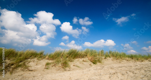 Dune beach on the North Sea island Langeoog in Germany with blue sky and clouds on a beautiful summer day