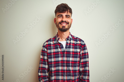 Young man wearing casual shirt standing over isolated white background with a happy and cool smile on face. Lucky person. © Krakenimages.com