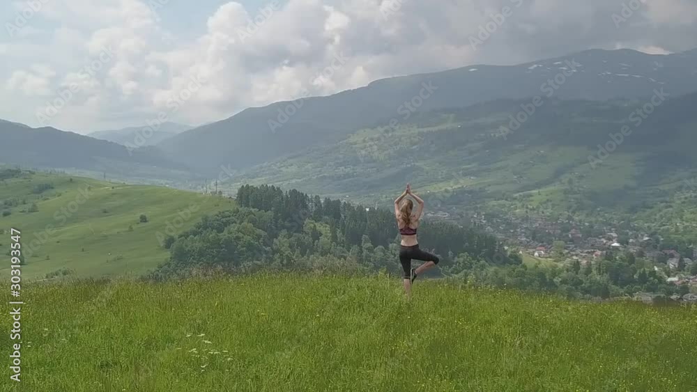 Young woman enjoying mountain view on a summer day. Relax and meditation in nature environment.