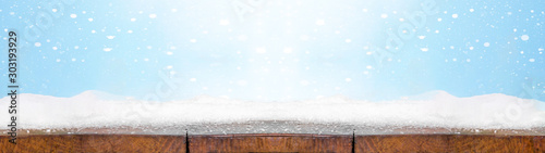 Christmas winter snow background banner - Snowy wooden rustic table - Background blue sky with snowflakes