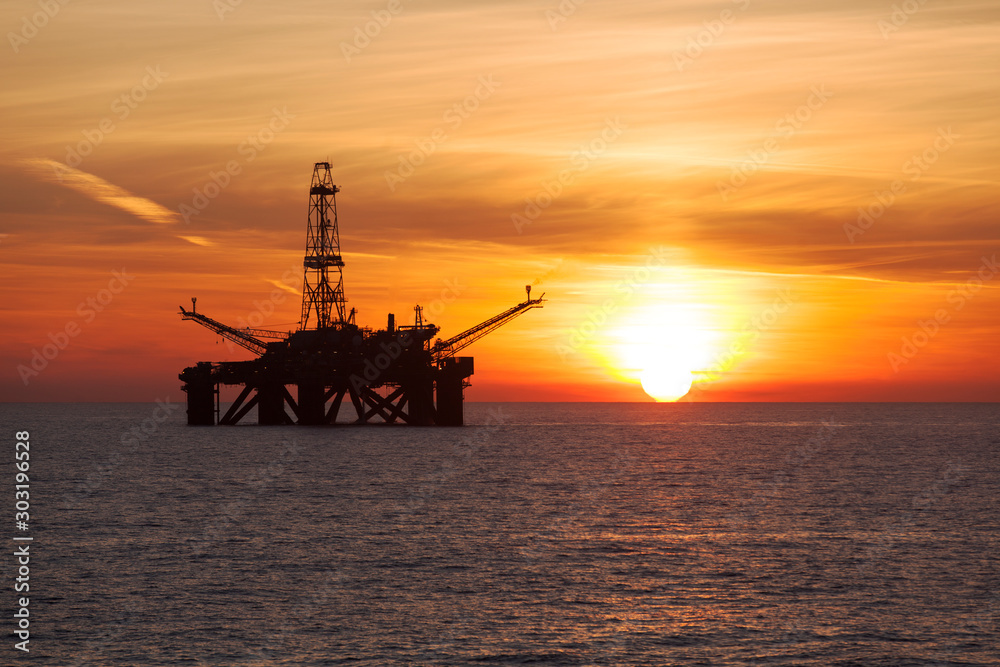 Silhouette of offshore oil rig at sunset