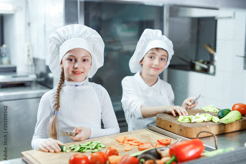 Children grind vegetables in the kitchen. Children grind vegetables in the kitchen.
