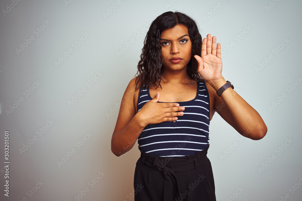 Transsexual transgender woman wearing striped t-shirt over isolated white background Swearing with hand on chest and open palm, making a loyalty promise oath Transsexual transgender woman wearing striped t-shirt over isolated white background Swearing with hand on chest and open palm, making a loyalty promise oath