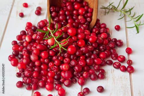 Cowberries from wild forest, red bilberries, cranberries in a rustic bowl on a white shabby wooden background
