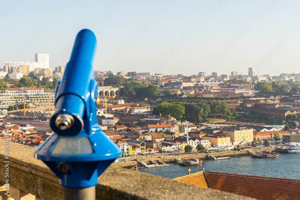sightseeing coin operated binocular. touristic viewfinder or telescope  against city panoramic view.