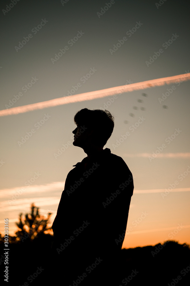 Silhouette of young man at sunset 