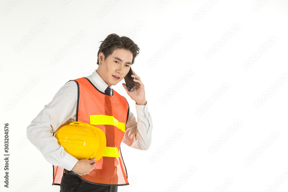 Portrait of smart young asian engineer businessman wearing white shirt and safety vest and helmet holding and talking smart mobile phone on isolated white background and copy space. Portrait of smart young asian engineer businessman wearing white shirt and safety vest and helmet holding and talking smart mobile phone on isolated white background and copy space.