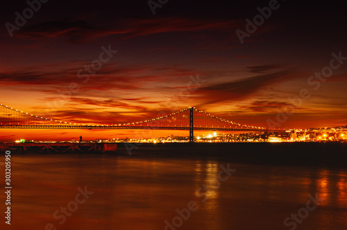 Most 25 kwietnia, łączący Lizbonę, stolicę Portugalii z Almada, zachód słońca.