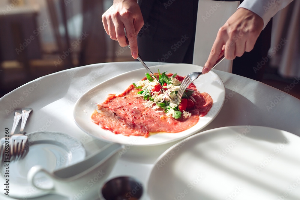 Red beef carpaccio in a white plate,