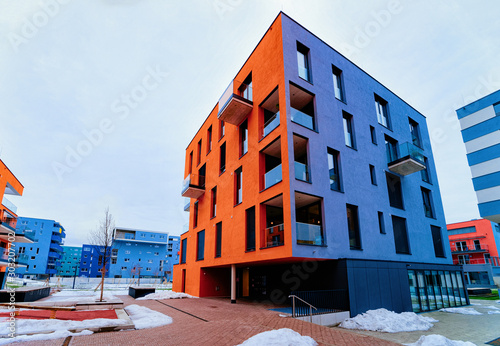 Colorful Modern residential apartment and flat buildings exterior in Salzburg, Austria. New luxury house and home complex of blue and red color. City Real estate property and condo architecture.
