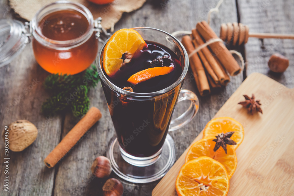 Hot mulled wine with orange, cinnamon, honey and anise on wooden background. Hot mulled wine with orange, cinnamon, honey and anise on wooden background.