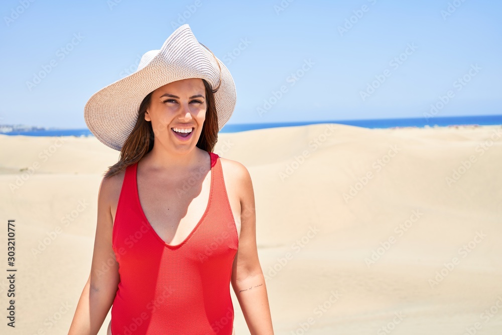 Young beautiful woman sunbathing wearing summer swinsuit at maspalomas dunes bech Young beautiful woman sunbathing wearing summer swinsuit at maspalomas dunes bech