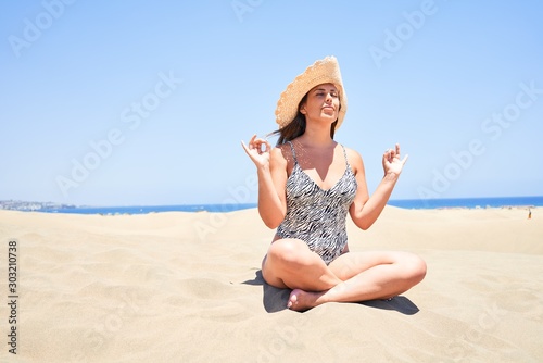Wallpaper Mural Young beautiful woman sunbathing and relaxing sitting on the sand doing yoga poses at maspalomas dunes bech Torontodigital.ca