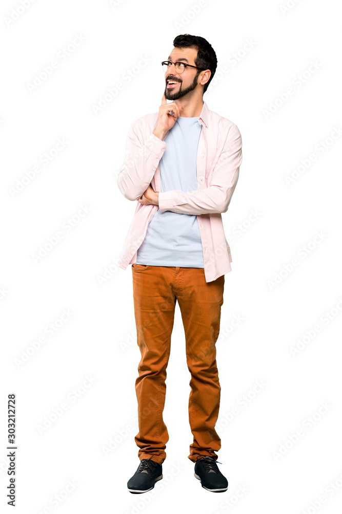 Full-length shot of Handsome man with beard thinking an idea while looking up over isolated white background Full-length shot of Handsome man with beard thinking an idea while looking up over isolated white background