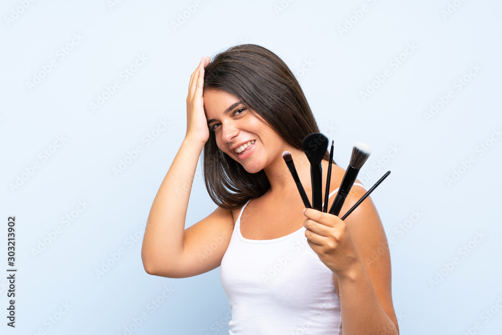 Young girl holding a lot of makeup brush has realized something and intending the solution Young girl holding a lot of makeup brush has realized something and intending the solution
