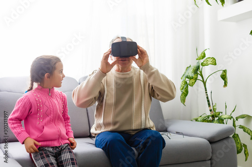 Senior man wearing virtual reality goggles at home