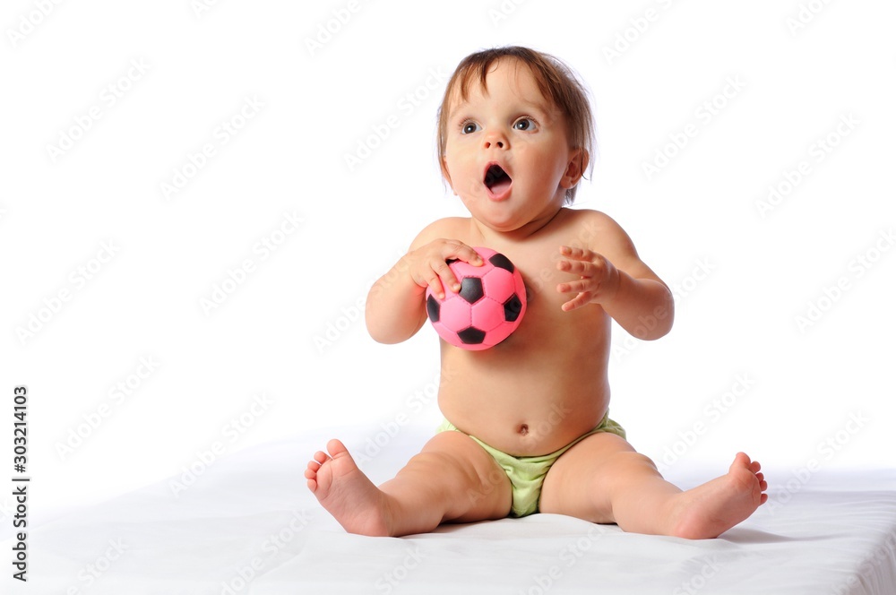 Little adorable baby girl plays with small pink football ball. Loved toy of child. Portrait on light background Little adorable baby girl plays with small pink football ball. Loved toy of child. Portrait on light background