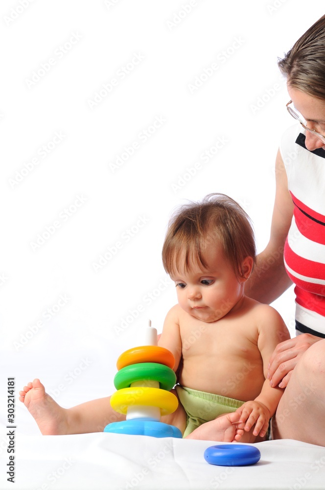 Funny training play of colorful pyramid with loved mother. Little baby sitting and playing toy with parent. Isolated on white background Funny training play of colorful pyramid with loved mother. Little baby sitting and playing toy with parent. Isolated on white background