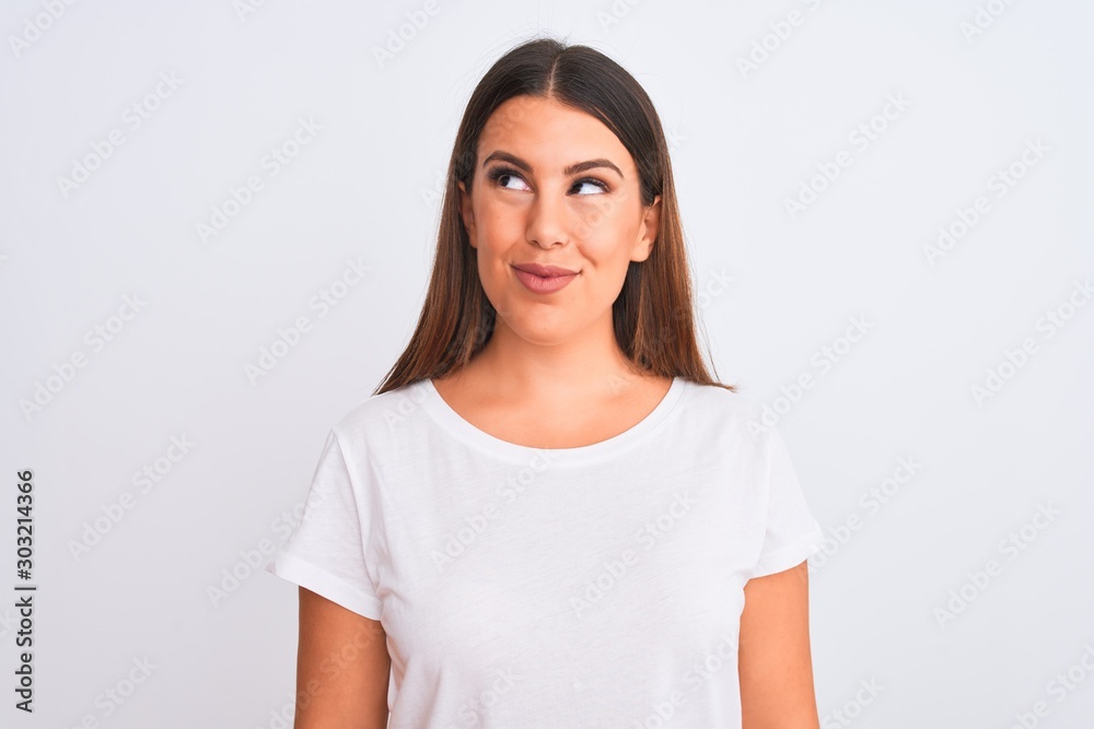 Fototapeta premium Portrait of beautiful and young brunette woman standing over isolated white background smiling looking to the side and staring away thinking.