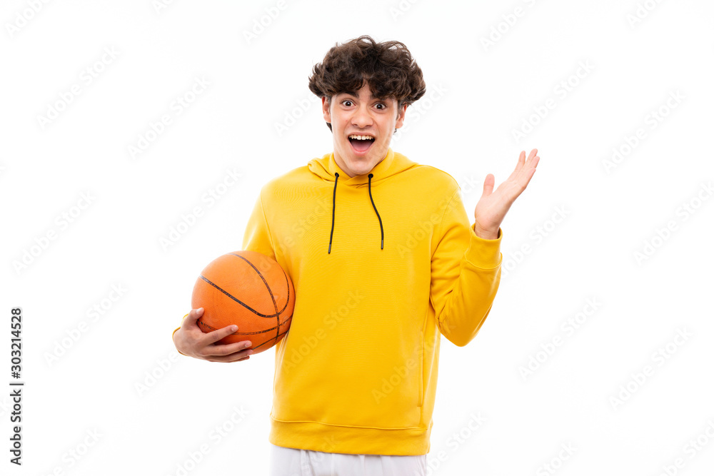 Young basketball player man over isolated white wall with shocked facial expression